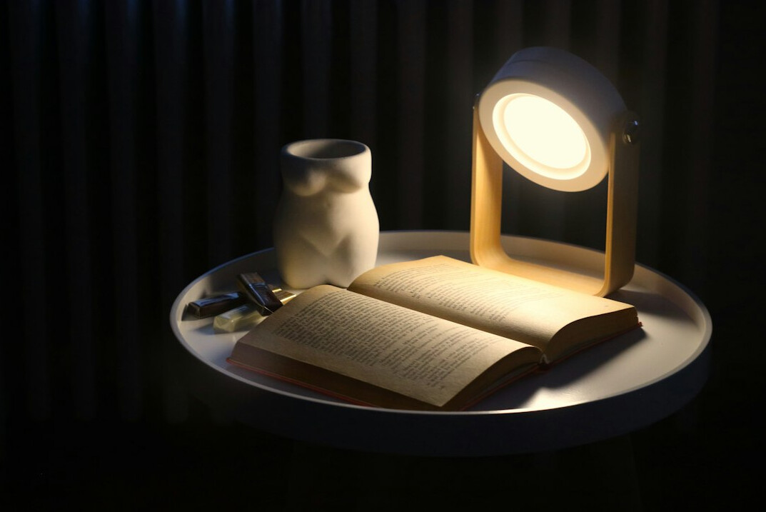 Open book with a reading lamp in the evening